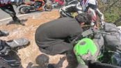Motorcyclist loses control during turn and slides straight into already crashed bike during crowded riding event.